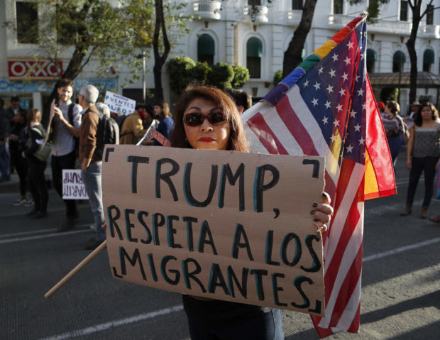 A woman holds a sign that reads in Spanish 