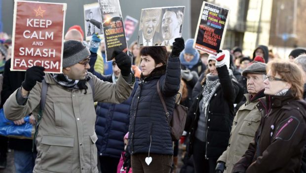 A participant of a Women's March in Helsinki holds up a poster depicting US President Donald Trump and German dictator Adolf Hitler on January 21, 2017, one day after the US president's inauguration. / AFP PHOTO / Lehtikuva / Jussi Nukari / Finland OUTJUSSI NUKARI/AFP/Getty Images NYTCREDIT: Jussi Nukari/Agence France-Presse -- Getty Images