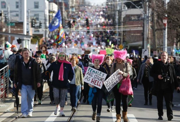 People march down South Jackson Street during the Women's March in Seattle, Washington on January 21, 2017. Led by women in pink "pussyhats," hundreds of thousands of people packed the streets of Washington and other cities Saturday in a massive outpouring of defiant opposition to America's hardline new president, Donald Trump. / AFP PHOTO / Jason RedmondJASON REDMOND/AFP/Getty Images NYTCREDIT: Jason Redmond/Agence France-Presse -- Getty Images